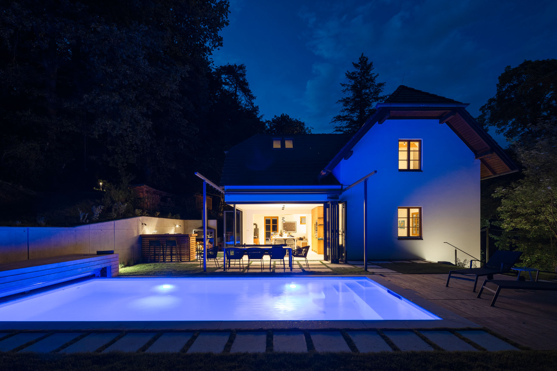 Pool beleuchtet vor saniertem Haus